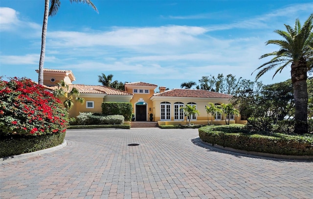 mediterranean / spanish-style home with stucco siding and a tiled roof