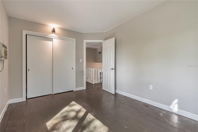 unfurnished bedroom with baseboards, a closet, and wood finished floors