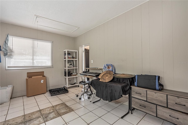 interior space featuring light tile patterned floors and attic access