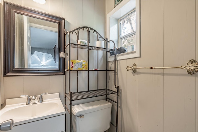 half bathroom featuring vanity and toilet