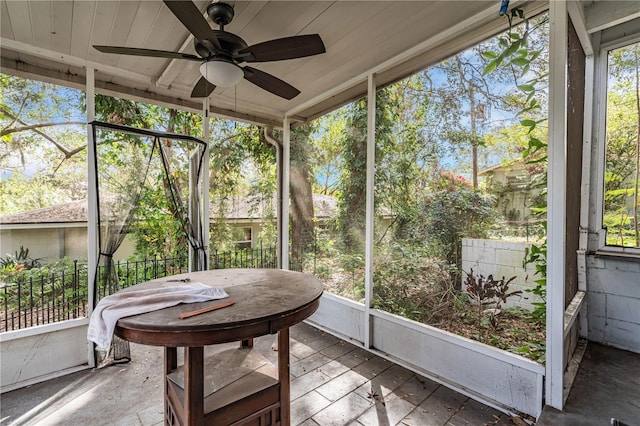 unfurnished sunroom featuring a ceiling fan