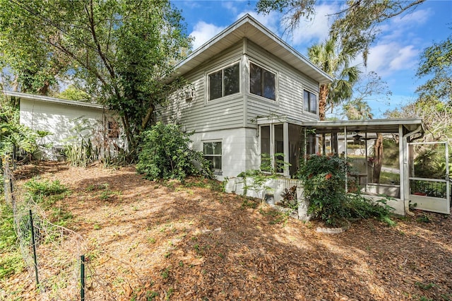 rear view of property featuring a sunroom