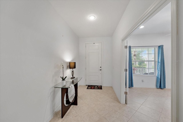 foyer entrance with light tile patterned floors and baseboards