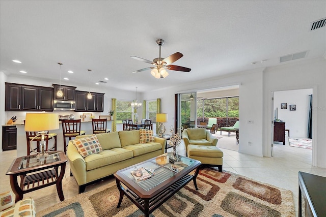 living room featuring light tile patterned floors, ceiling fan with notable chandelier, visible vents, and recessed lighting