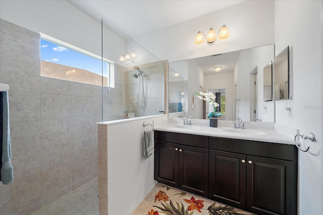 bathroom with double vanity, a walk in shower, and a sink