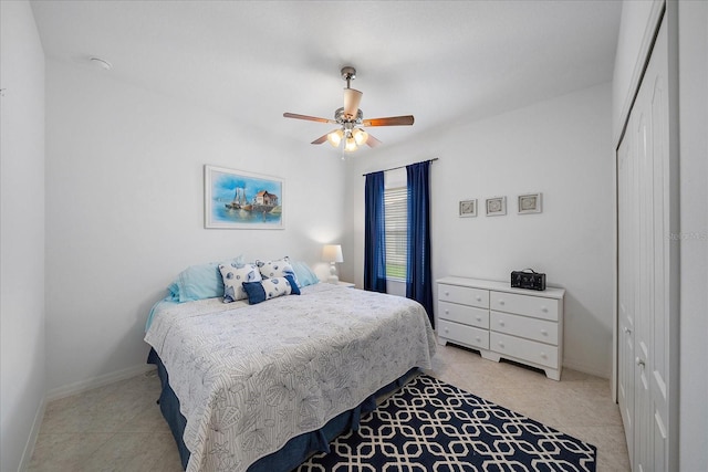 bedroom with ceiling fan, a closet, and baseboards