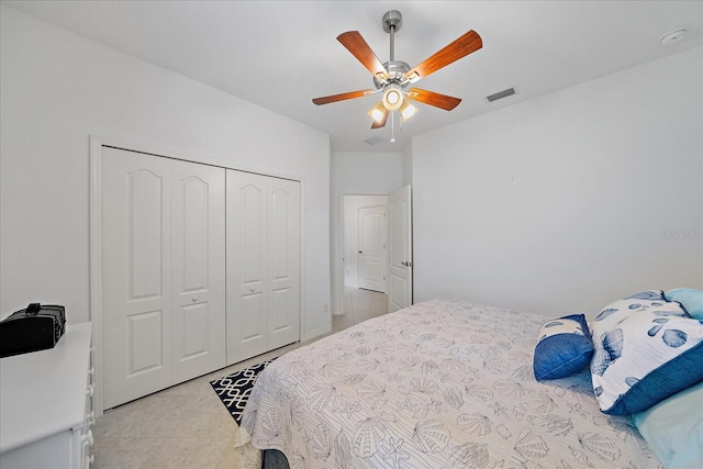 bedroom featuring light tile patterned floors, a ceiling fan, visible vents, and a closet