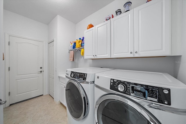 laundry room featuring light tile patterned floors, washing machine and dryer, and cabinet space