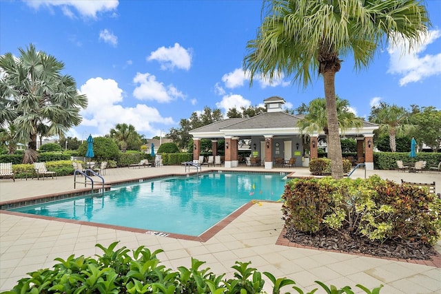 pool featuring fence, a patio, and a gazebo