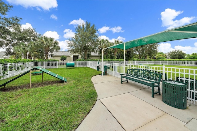 view of home's community with a yard and fence