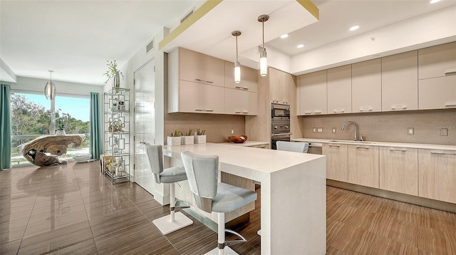 kitchen with appliances with stainless steel finishes, light countertops, a sink, and modern cabinets