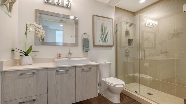 bathroom with toilet, a stall shower, visible vents, and vanity