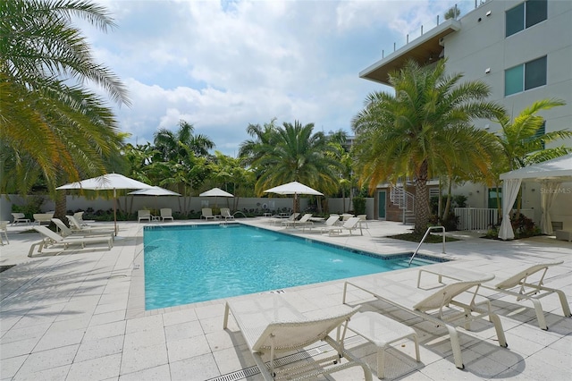 community pool with fence and a patio