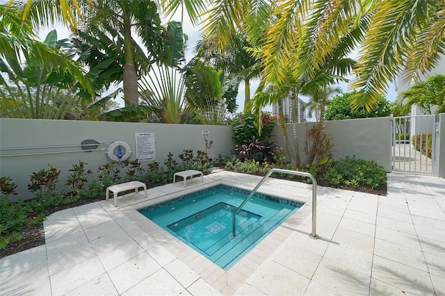 view of pool with a community hot tub, a fenced backyard, and a patio