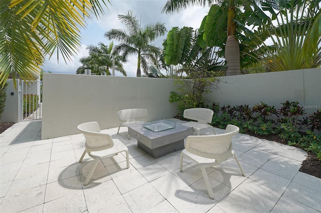 view of patio featuring an outdoor fire pit, a gate, and fence