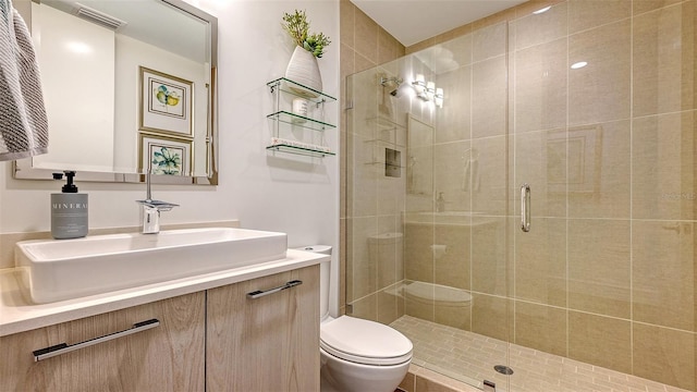 bathroom featuring visible vents, a shower stall, toilet, and vanity