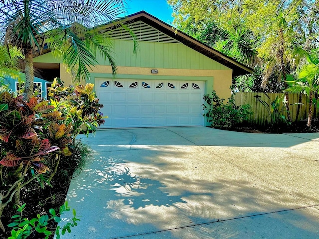 garage with driveway and fence