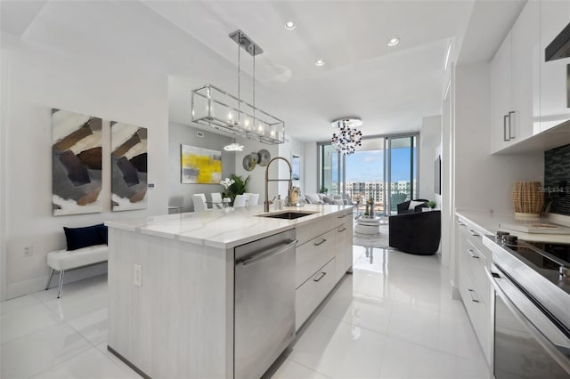 kitchen with a kitchen island with sink, a sink, stainless steel dishwasher, floor to ceiling windows, and modern cabinets