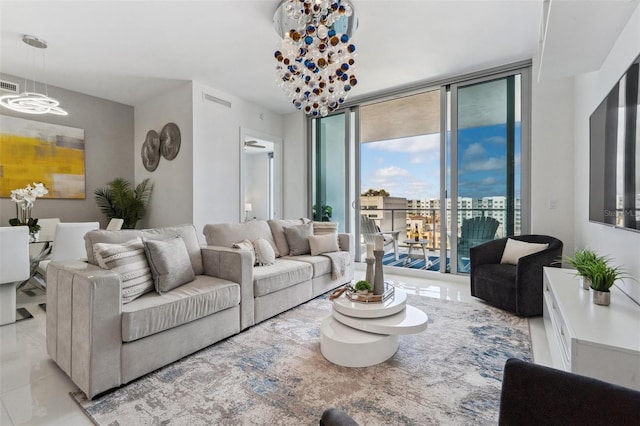 living room featuring a wall of windows, visible vents, and an inviting chandelier