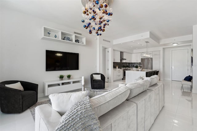 living room featuring light tile patterned flooring, a notable chandelier, and visible vents