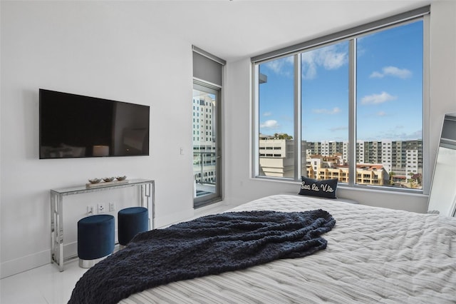 bedroom featuring access to exterior and baseboards