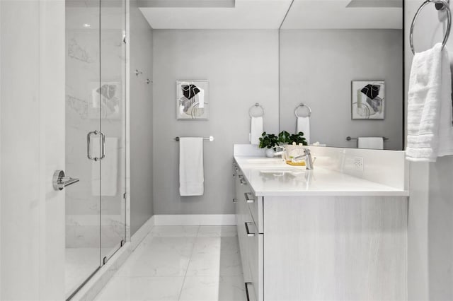 full bath featuring marble finish floor, a marble finish shower, vanity, and baseboards