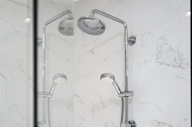 interior details featuring a marble finish shower