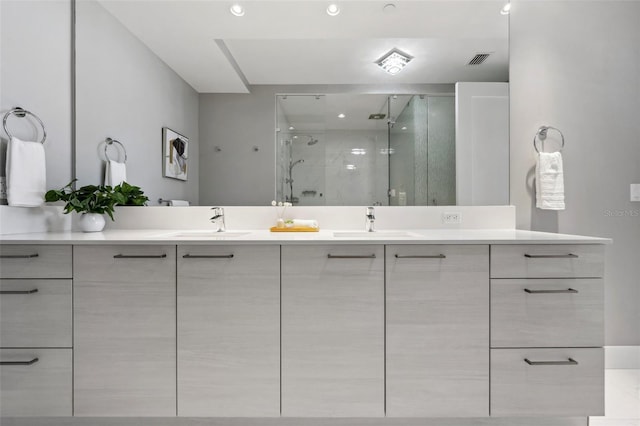 bathroom featuring double vanity, a sink, visible vents, and a shower stall