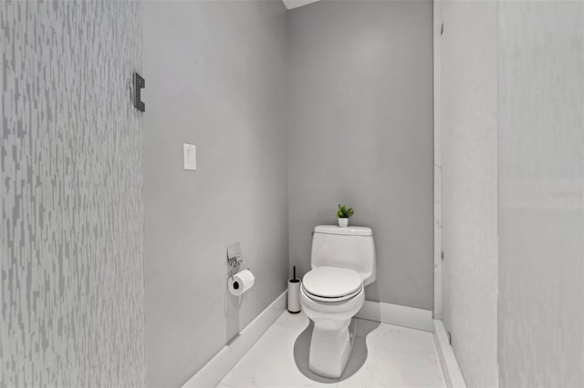 bathroom with tile patterned flooring, toilet, and baseboards