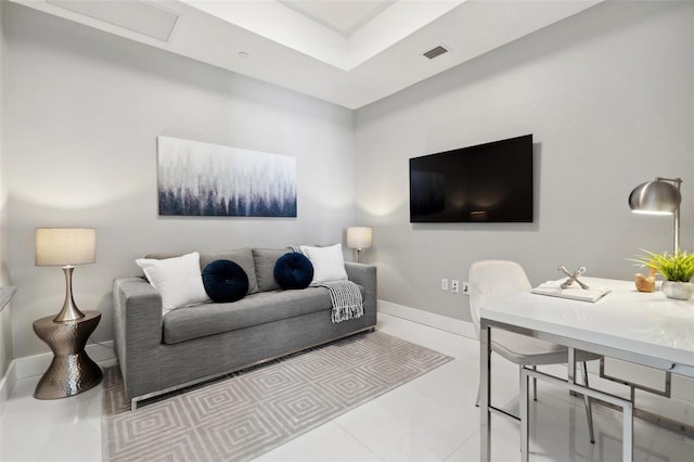 living room with tile patterned flooring, visible vents, and baseboards