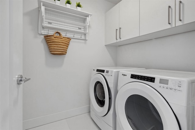 washroom featuring cabinet space, light tile patterned floors, baseboards, and separate washer and dryer