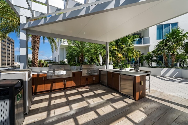 view of patio / terrace with a sink, a view of city, exterior kitchen, and a grill