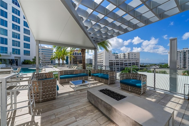 view of patio / terrace with a view of city, an outdoor living space with a fire pit, and a community pool