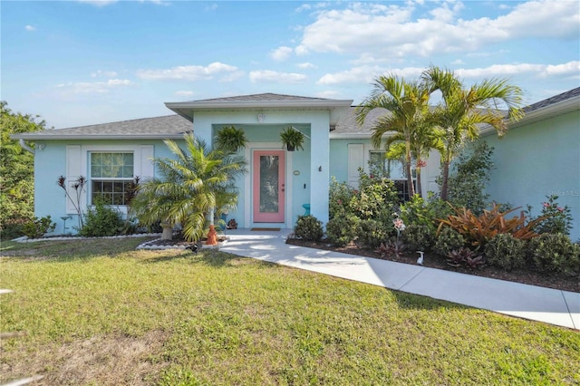 view of front of property featuring a front lawn and stucco siding