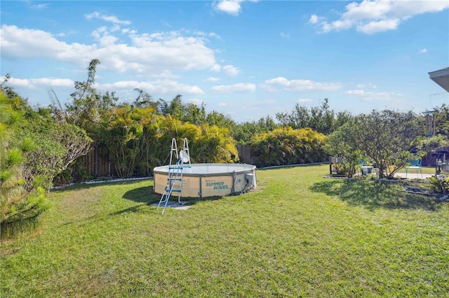 view of yard with an outdoor pool and fence