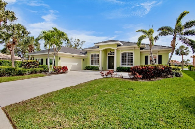 view of front of property with driveway, a front lawn, an attached garage, and stucco siding