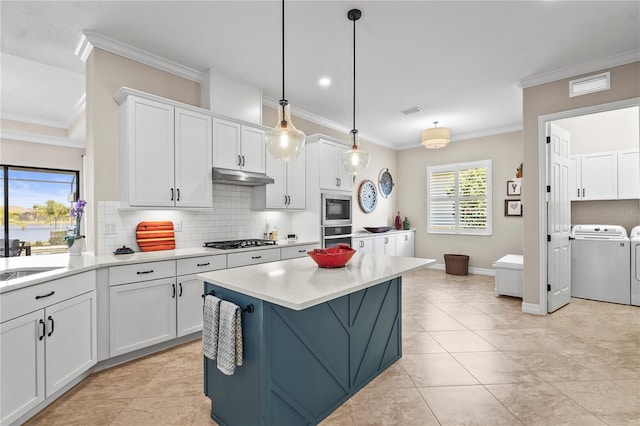 kitchen featuring light countertops, white cabinets, appliances with stainless steel finishes, under cabinet range hood, and washer and clothes dryer