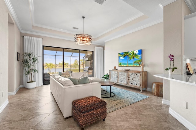 living room featuring a tray ceiling, baseboards, visible vents, and ornamental molding