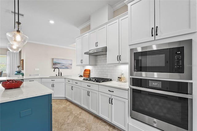 kitchen featuring under cabinet range hood, appliances with stainless steel finishes, white cabinetry, crown molding, and backsplash