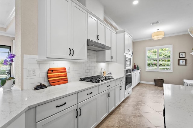 kitchen with tasteful backsplash, crown molding, under cabinet range hood, white cabinets, and stainless steel appliances