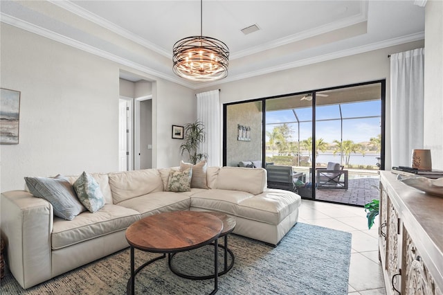 living room featuring visible vents, a tray ceiling, ornamental molding, light tile patterned floors, and a notable chandelier