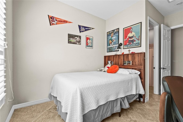 bedroom with light tile patterned floors and baseboards