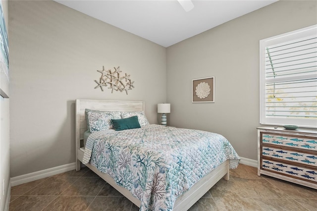 bedroom with tile patterned floors, a ceiling fan, and baseboards