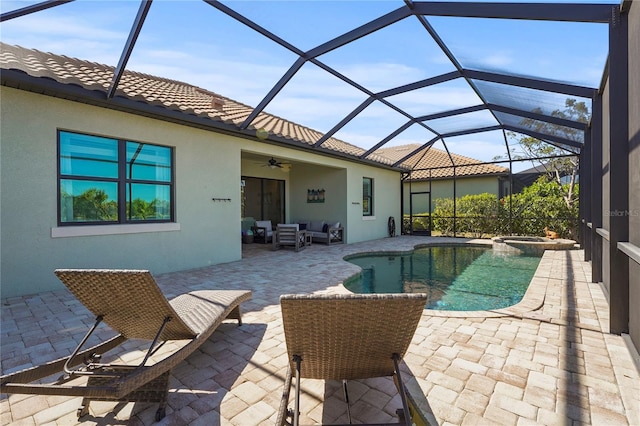 view of pool with a pool with connected hot tub, glass enclosure, an outdoor hangout area, ceiling fan, and a patio area