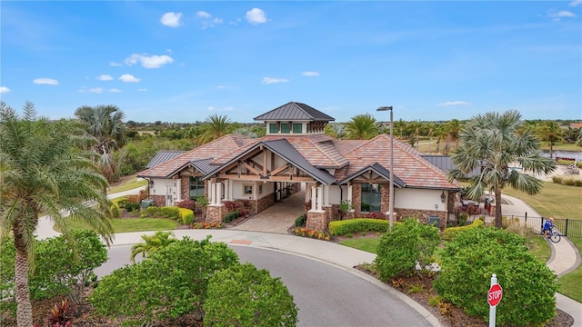 view of front of property featuring stucco siding, driveway, a standing seam roof, fence, and metal roof