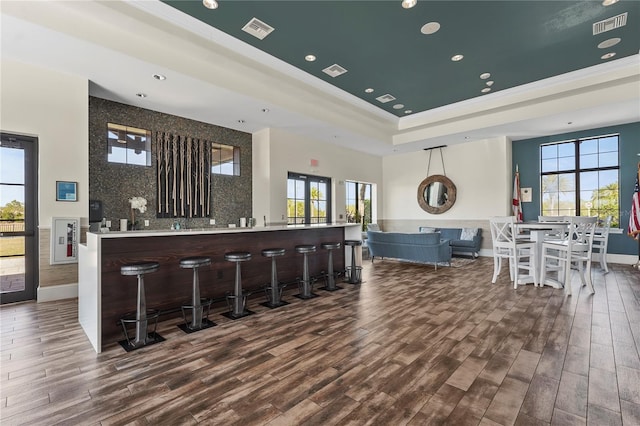 bar with plenty of natural light, wood finished floors, and visible vents