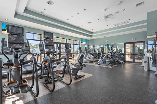 exercise room featuring visible vents, french doors, and a raised ceiling