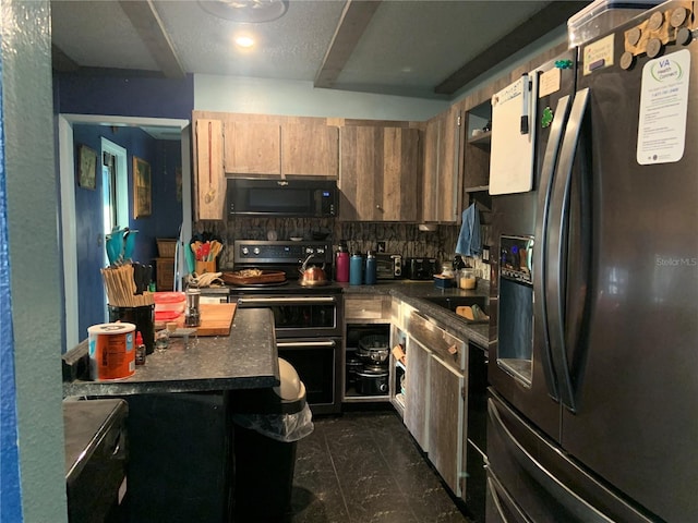 kitchen featuring dark countertops, black appliances, tasteful backsplash, and a sink