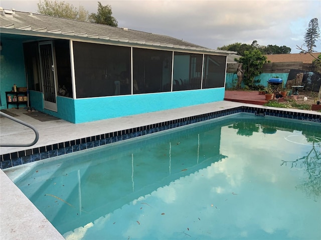 view of pool with a fenced in pool, a sunroom, and fence