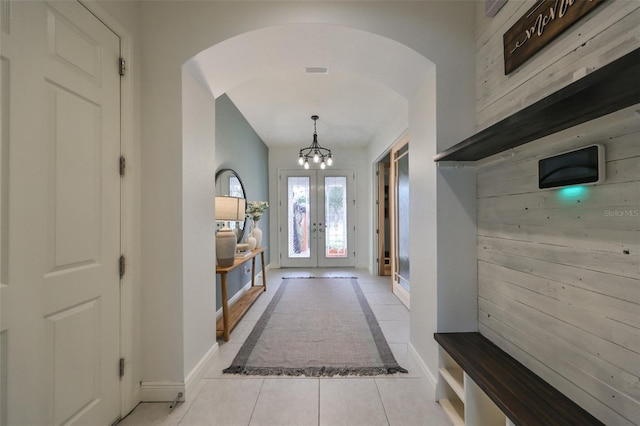 mudroom featuring french doors, a chandelier, tile patterned flooring, baseboards, and arched walkways